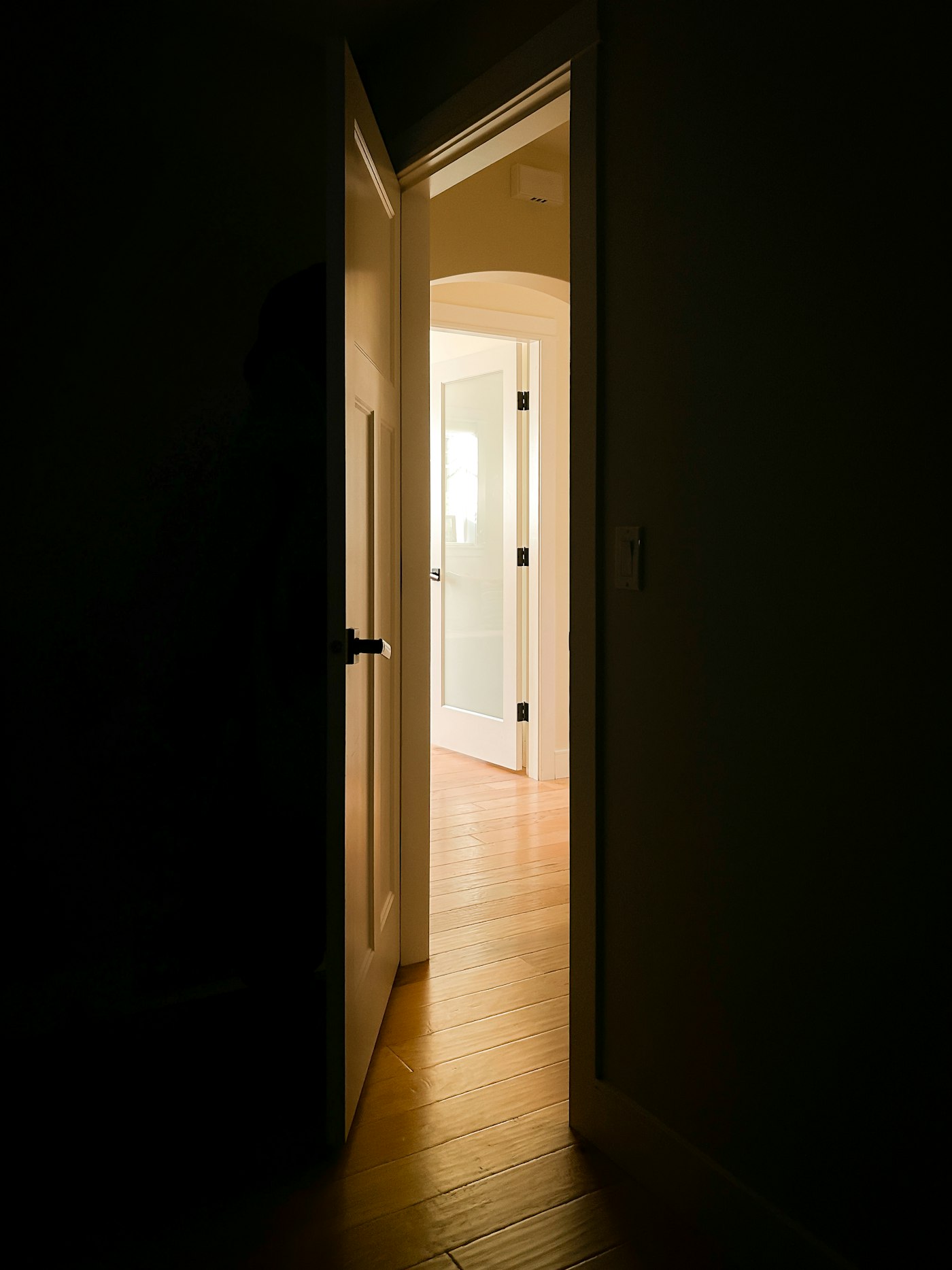 An open door letting warm light into a dark room
