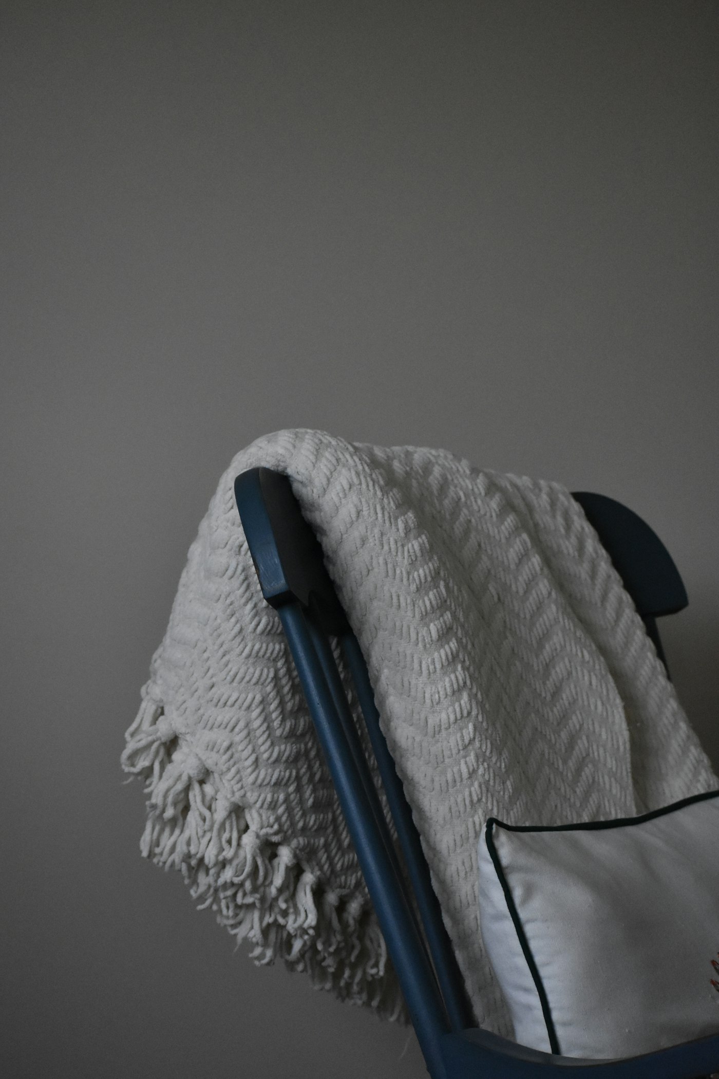 A soft woven blanket draped over a chair