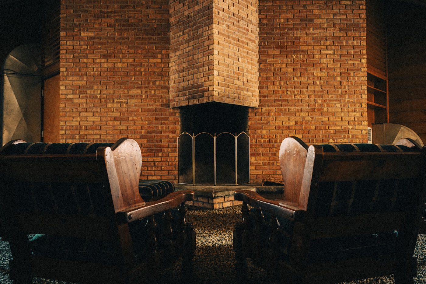 Two armchairs facing each other by a fireplace